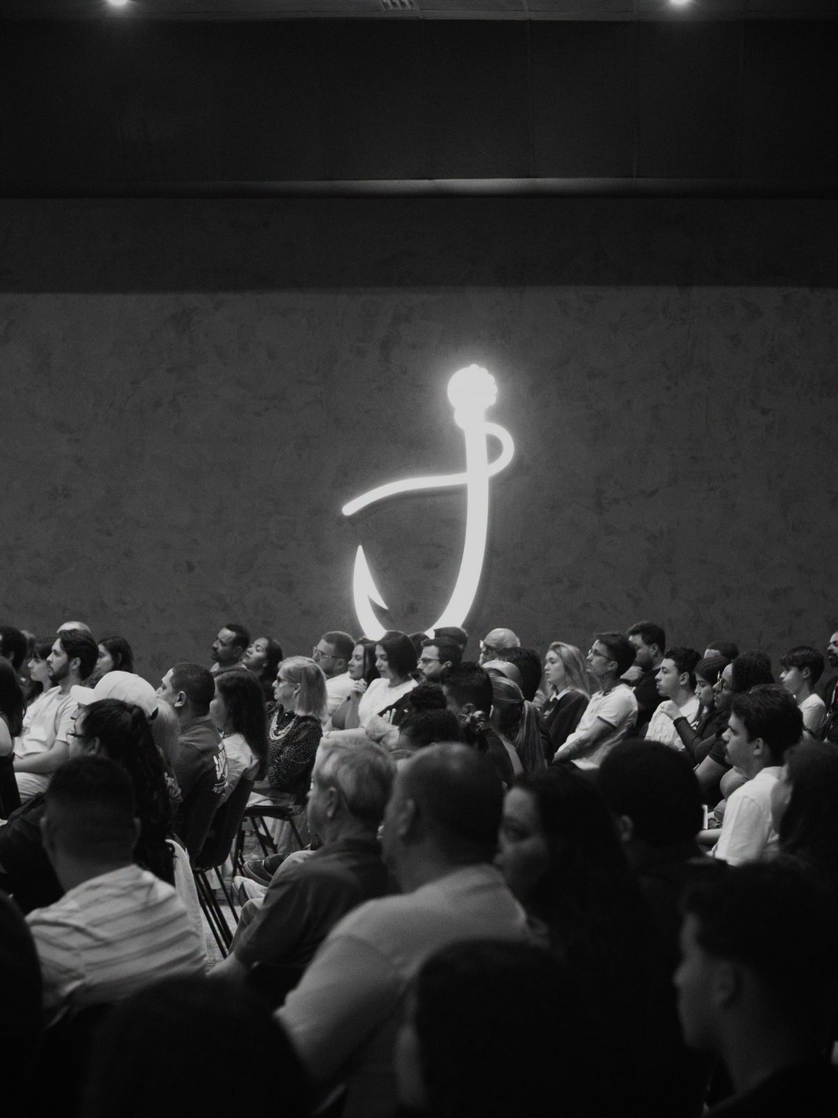Igreja reunida no culto, sob o anzol iluminado